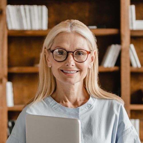 businesswoman-teacher-boss-freelancer-holding-laptop-looking-at-camera-in-glasses-in-office-library-e1656644395390.jpg businesswoman-teacher-boss-freelancer-holding-laptop-looking-at-camera-in-glasses-in-office-library-e1656644395390.jpg